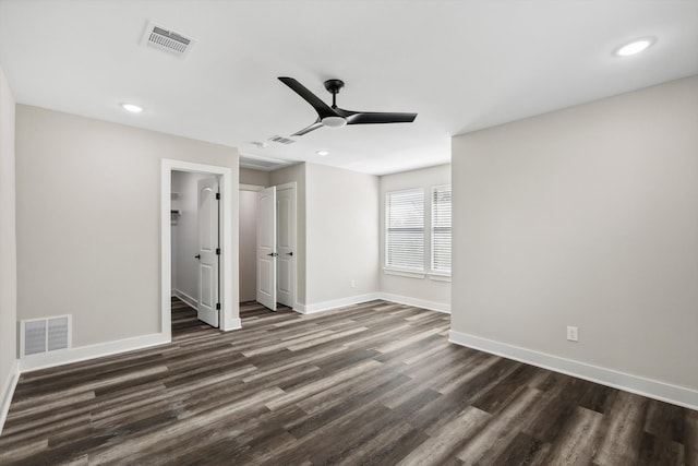 unfurnished bedroom with a spacious closet, ceiling fan, dark hardwood / wood-style floors, and a closet