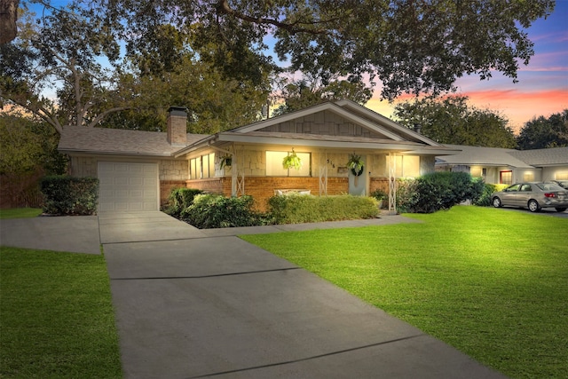 ranch-style home with a garage and a yard