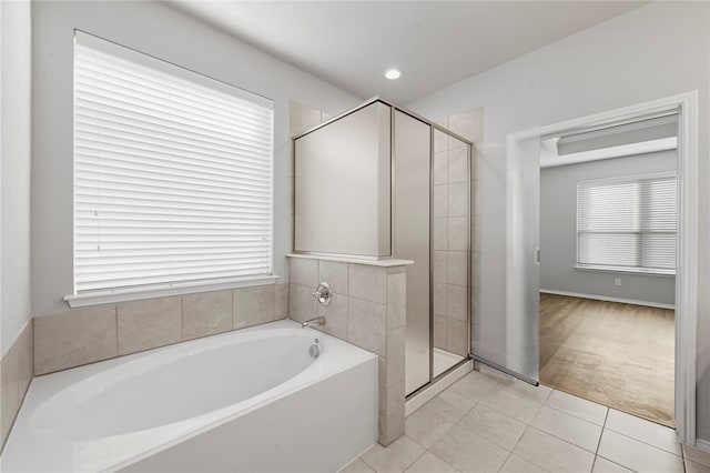 bathroom with tile patterned flooring and separate shower and tub