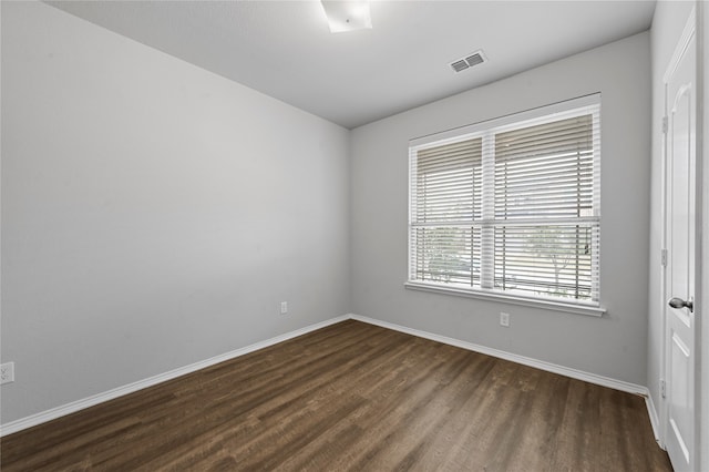 spare room with dark wood-type flooring