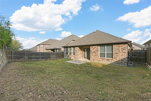 back of house with a lawn and a patio area