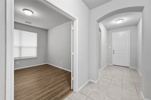 foyer entrance with a textured ceiling and light hardwood / wood-style floors