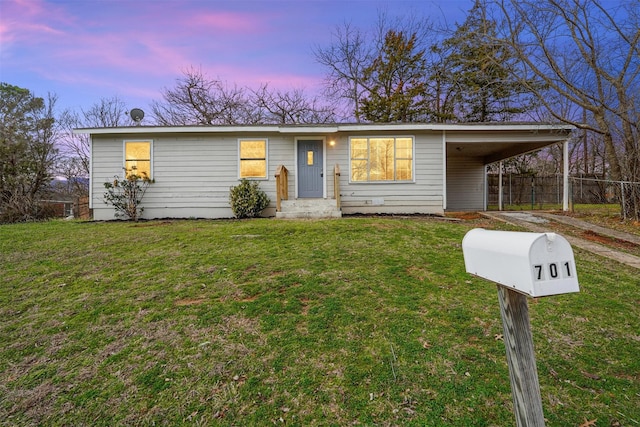 ranch-style house with a carport and a yard