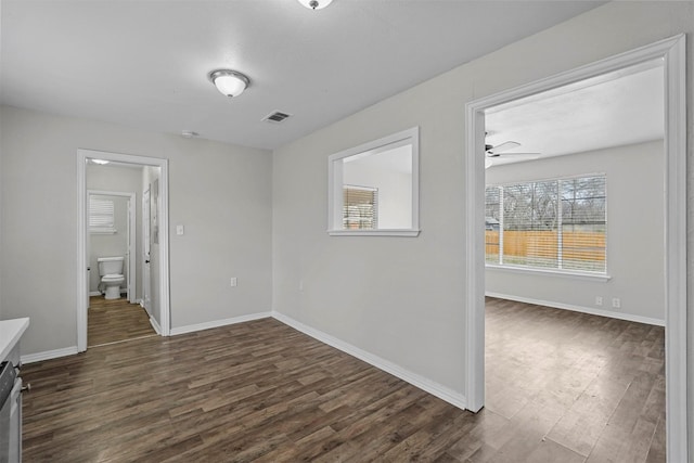 empty room with ceiling fan and dark hardwood / wood-style floors