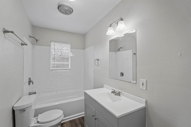 full bathroom with vanity, wood-type flooring, tiled shower / bath, and toilet