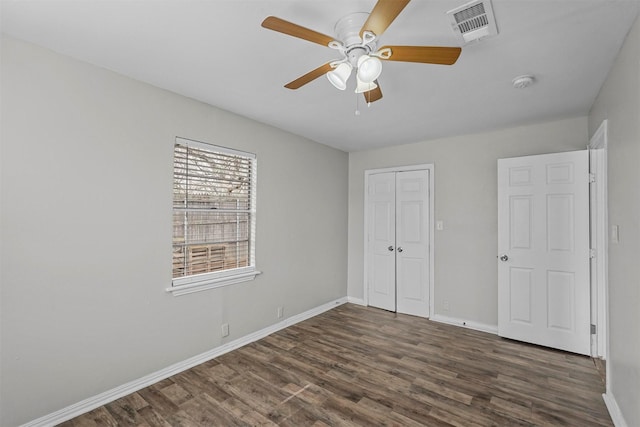 unfurnished bedroom with ceiling fan, dark hardwood / wood-style floors, and a closet