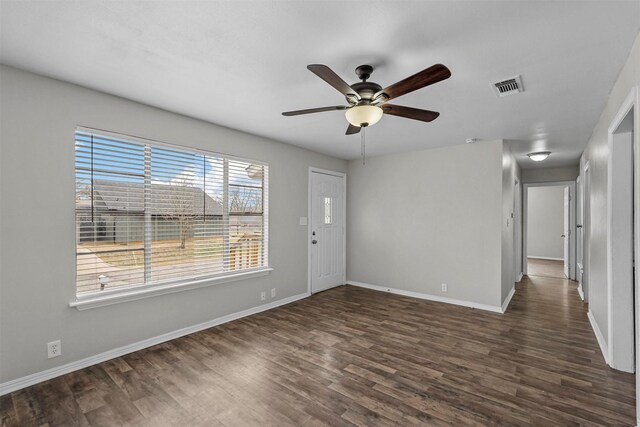 spare room featuring dark wood-type flooring and ceiling fan