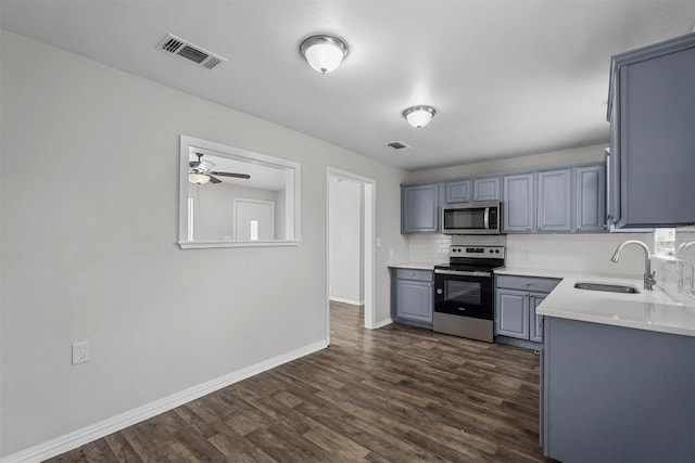 kitchen with gray cabinets, tasteful backsplash, sink, dark hardwood / wood-style flooring, and stainless steel appliances