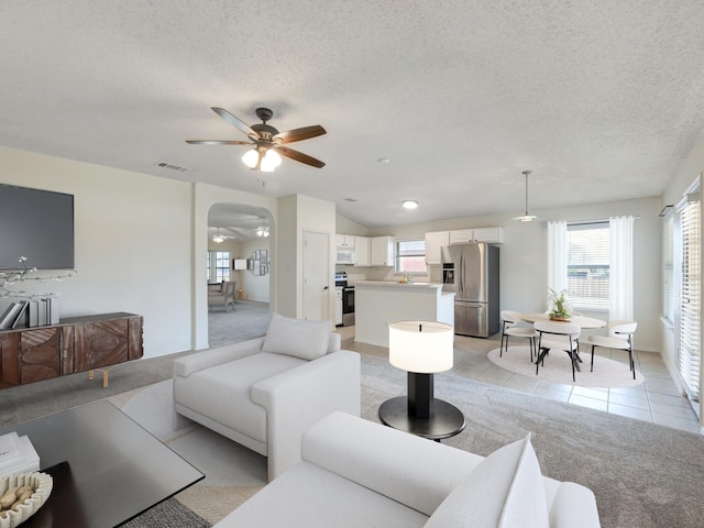 tiled living room with a textured ceiling and ceiling fan