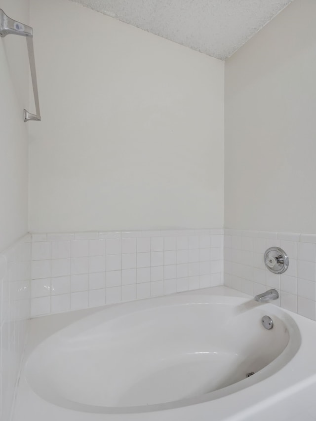 bathroom featuring a textured ceiling and a bathing tub