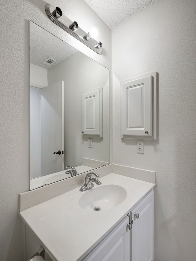 bathroom with vanity and a textured ceiling