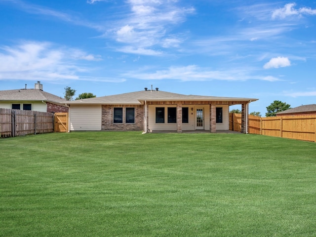 rear view of property featuring a lawn