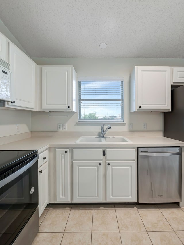 kitchen with dishwasher, black / electric stove, white cabinetry, and sink