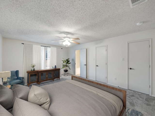 bedroom featuring a textured ceiling, carpet flooring, and ceiling fan