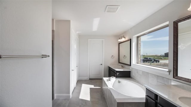 bathroom featuring tiled bath and vanity