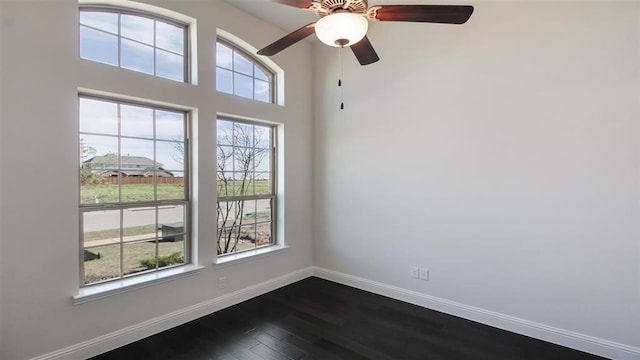 unfurnished room featuring plenty of natural light, ceiling fan, and dark hardwood / wood-style flooring