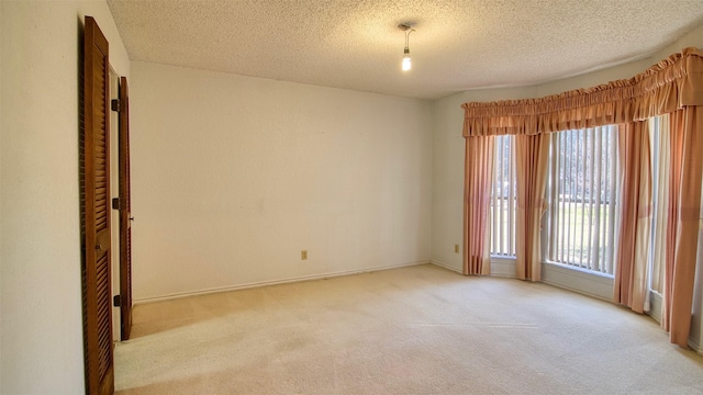 carpeted spare room featuring a textured ceiling