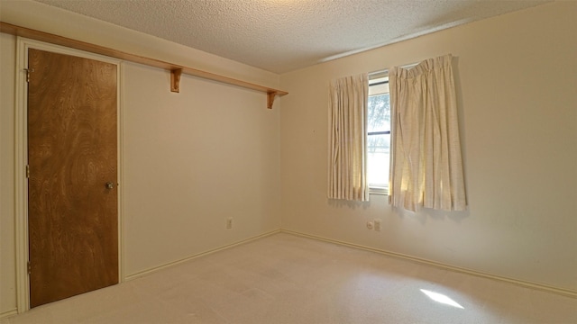 carpeted spare room with a textured ceiling