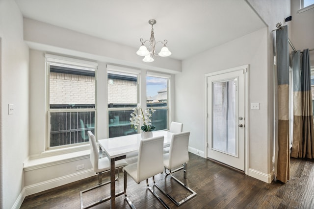 dining space with dark hardwood / wood-style flooring and a chandelier