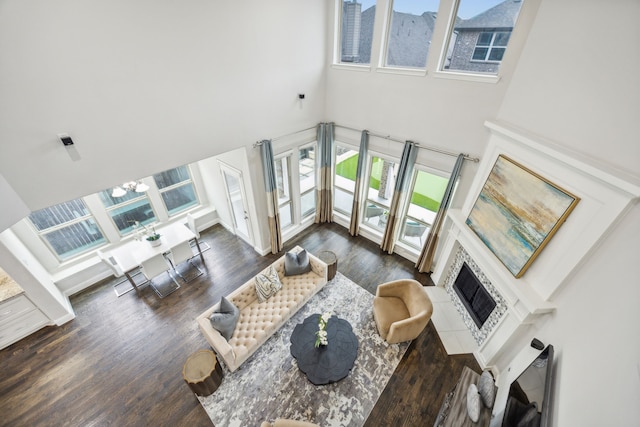 living room with dark hardwood / wood-style flooring, a chandelier, and a high ceiling