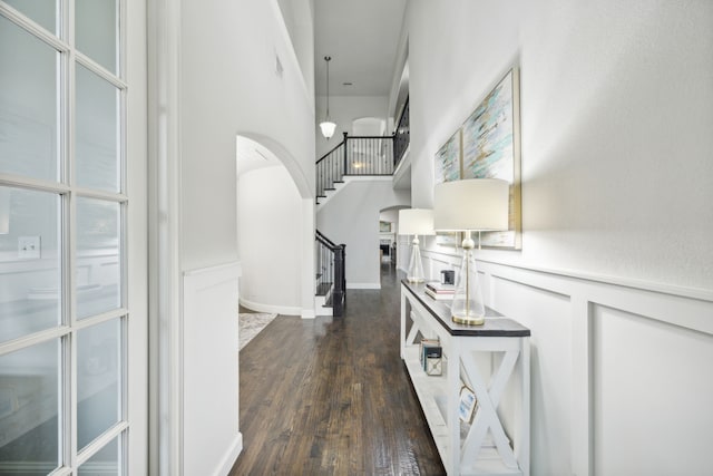 hall with dark hardwood / wood-style floors and a high ceiling