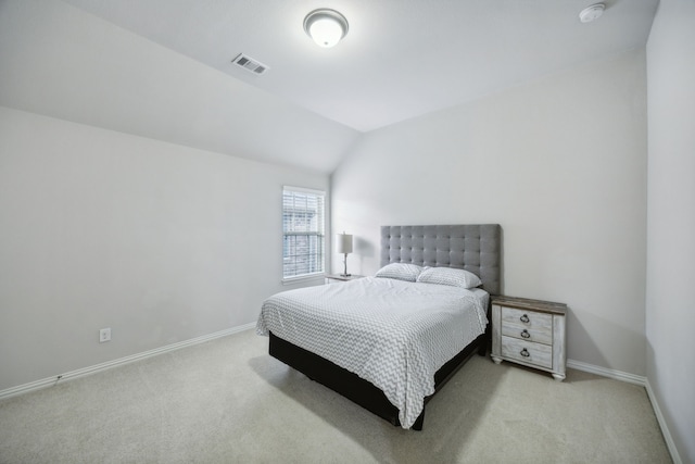 bedroom featuring light colored carpet and vaulted ceiling