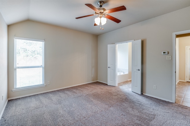 empty room featuring light colored carpet, ceiling fan, and vaulted ceiling