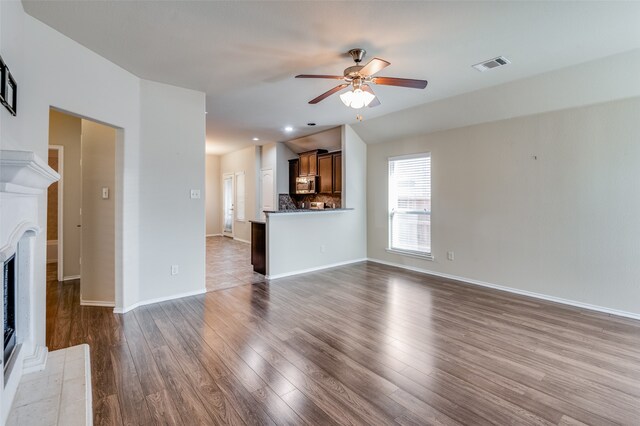 unfurnished living room with dark wood-type flooring and ceiling fan