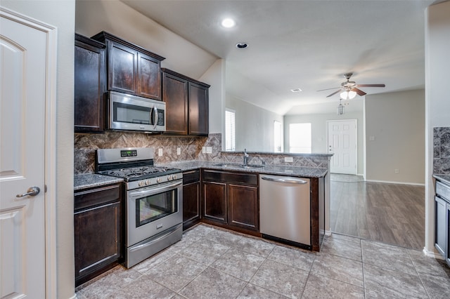 kitchen with tasteful backsplash, appliances with stainless steel finishes, sink, and dark brown cabinetry