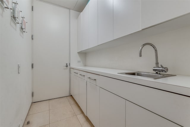 kitchen with white cabinetry, sink, and light tile patterned floors