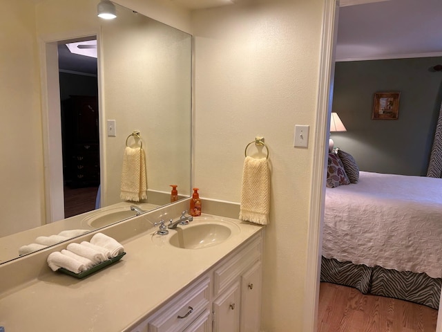 bathroom with ornamental molding, vanity, and wood-type flooring