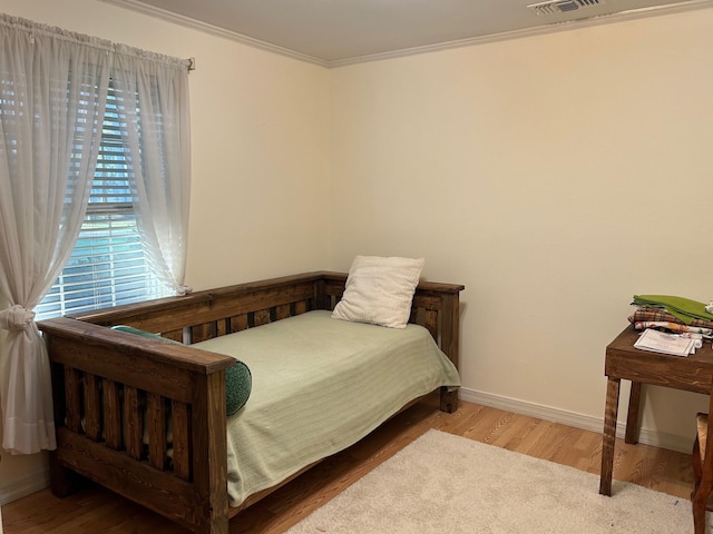 bedroom with crown molding and hardwood / wood-style flooring