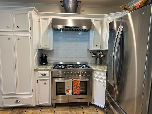 kitchen featuring white cabinetry, ventilation hood, appliances with stainless steel finishes, light stone countertops, and decorative backsplash