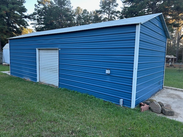 view of outbuilding featuring a garage and a lawn