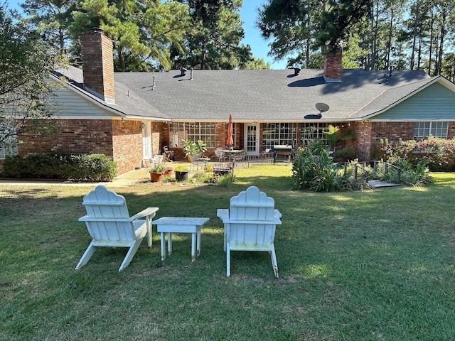 rear view of property with a yard