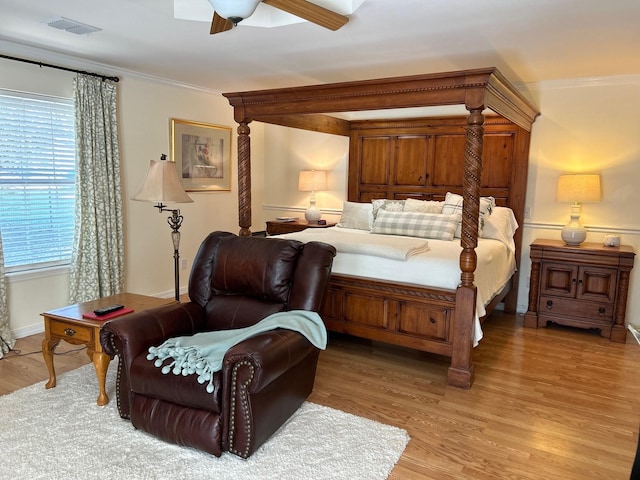 bedroom with ceiling fan, ornamental molding, and light wood-type flooring