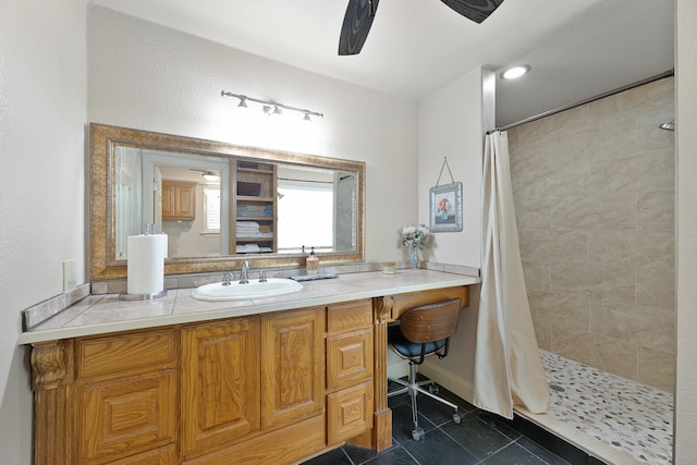 bathroom with a shower with curtain, vanity, tile patterned floors, and ceiling fan