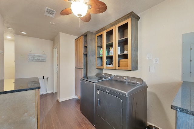 laundry room featuring ceiling fan, electric panel, washing machine and clothes dryer, and dark hardwood / wood-style floors