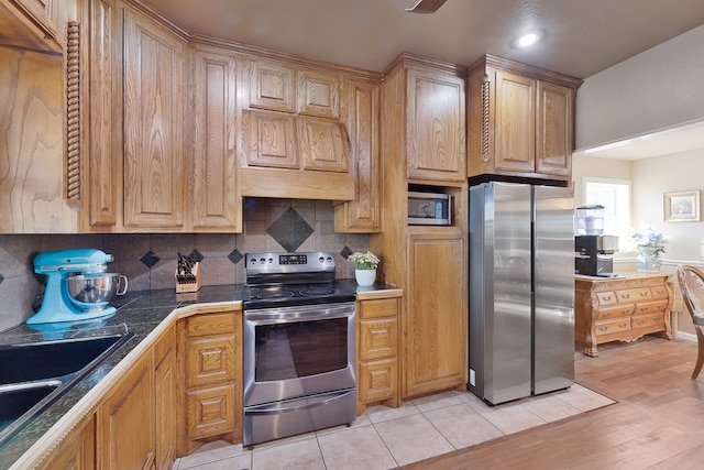 kitchen with appliances with stainless steel finishes, custom range hood, sink, decorative backsplash, and light hardwood / wood-style floors