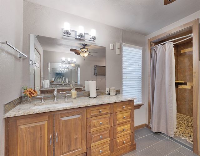 bathroom with tile patterned flooring, a textured ceiling, vanity, ceiling fan, and walk in shower