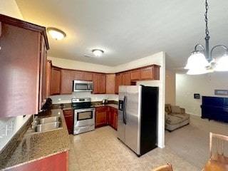 kitchen with pendant lighting, stainless steel appliances, a notable chandelier, and sink