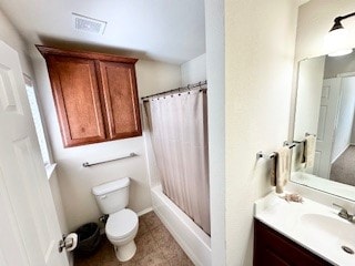 full bathroom featuring vanity, shower / bath combo with shower curtain, and toilet