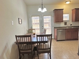 dining room with a healthy amount of sunlight, sink, french doors, and a notable chandelier