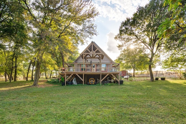 rear view of house featuring a yard and a wooden deck