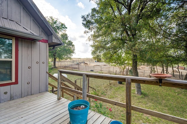 wooden terrace with a rural view and a lawn