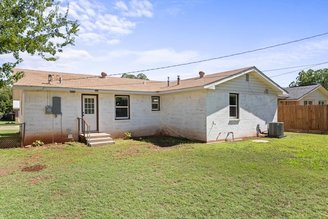 back of house with central AC and a yard