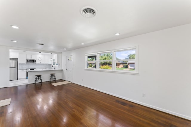 unfurnished living room with dark wood-type flooring and sink