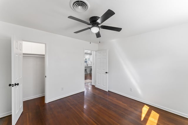 unfurnished bedroom featuring dark wood-type flooring, ceiling fan, and a closet