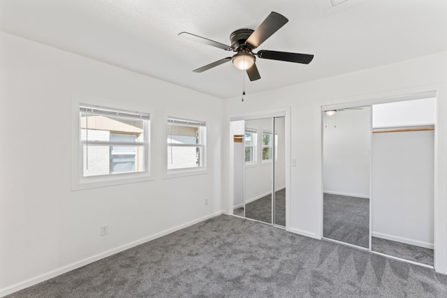 unfurnished bedroom with ceiling fan and dark carpet