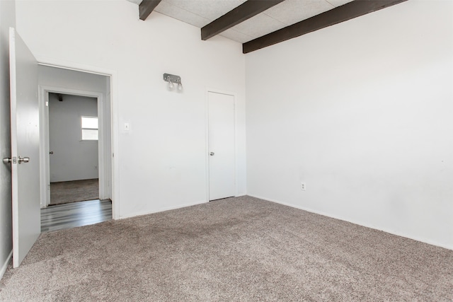 spare room featuring beam ceiling and carpet flooring